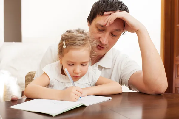 Father helping daughter doing homework