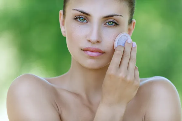 Calm young woman handles face creams