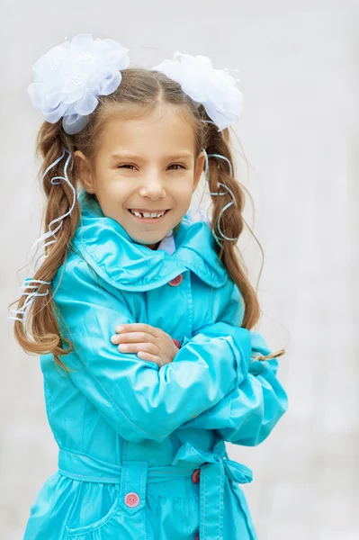 Smiling beautiful girl with bows in blue cloak