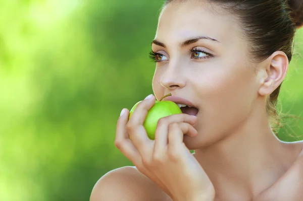 Beautiful young woman with green apple