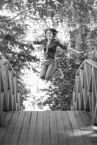 Jump girl on summer bridge