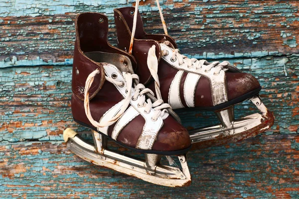 Vintage pair of mens ice skates on a wooden wall