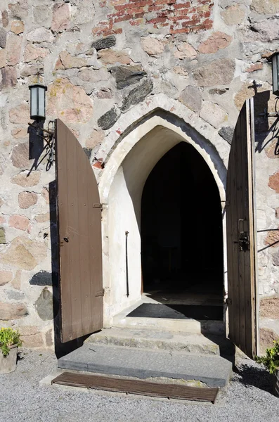 Open doors of medieval stone church