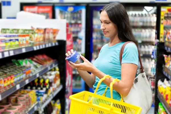 A woman buys tinned meat