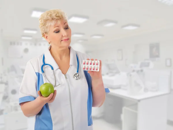 Mature doctor with apple and pills