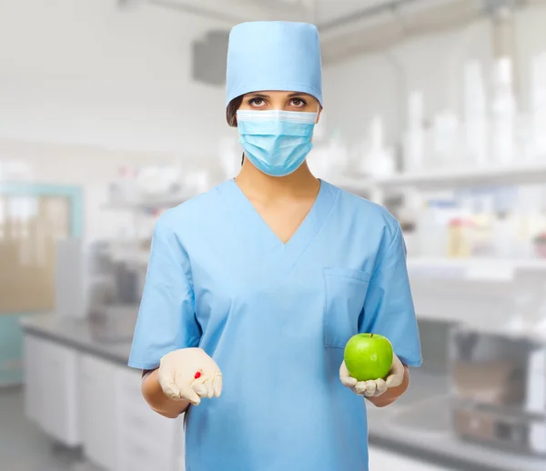 Doctor with pill and apple
