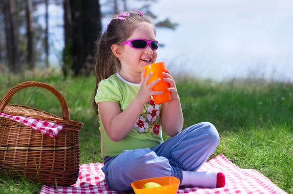 Little girl with plastic cup and picnic basket