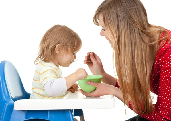 Mom giving food to her son