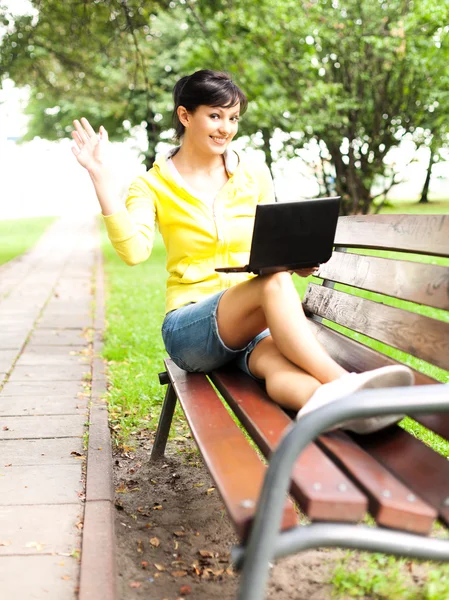 Young woman with laptop in the park