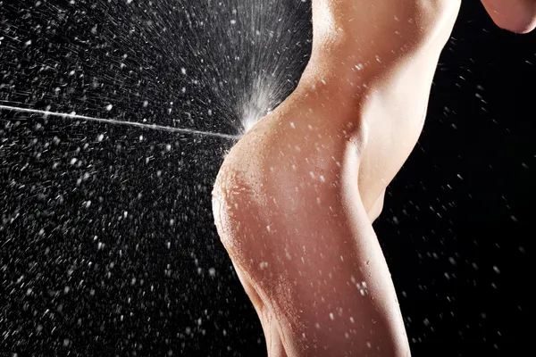 Water splashing on fit nude female body
