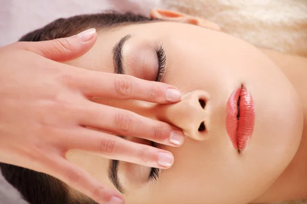 Woman enjoy receiving face massage at spa saloon