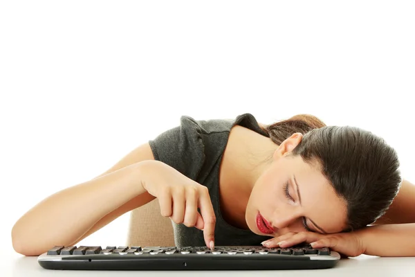Tired businesswoman typing on keyboard
