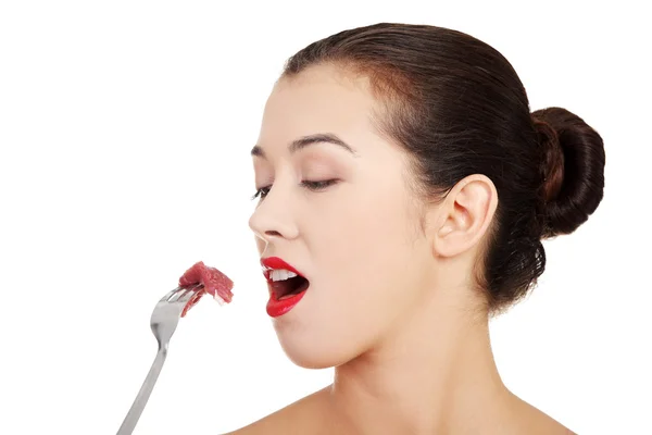 Young beautiful woman eating raw meat.