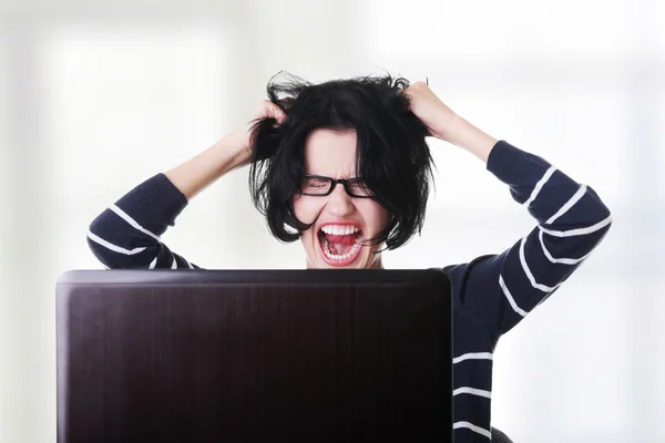 Frustrated woman working on laptop