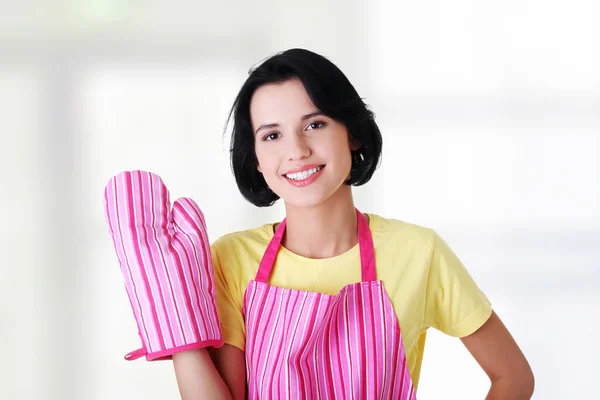 Young housewife in pink apron ang glove
