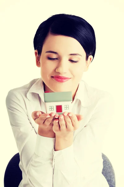 Businesswoman hands holding and protecting house.