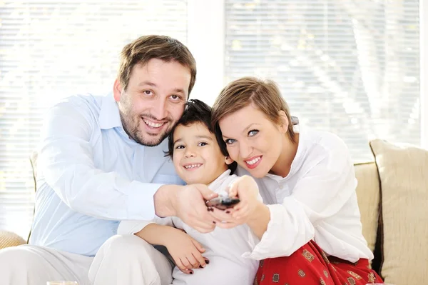 Family sitting in living room with remote control