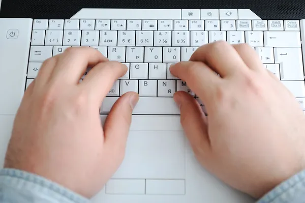 Man typing on a computer keyboard