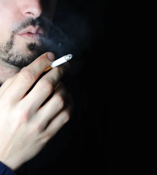 Man smoking in dark with visible smoke