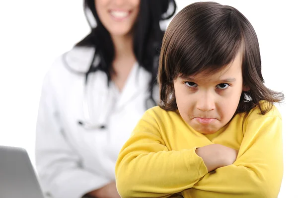 Young female doctor examining little cute angry child refusing examining