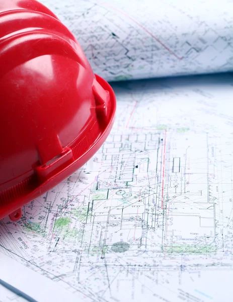 Close up of architectural drawings and red helmet