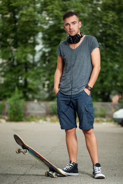 Handsome guy with headphones and skateboard