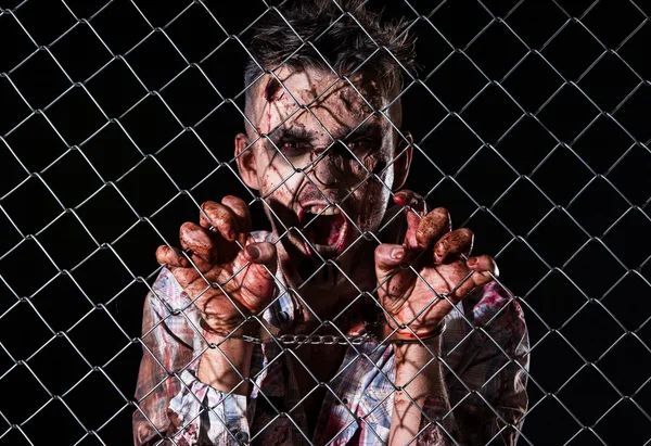 Scary zombie behind the fence