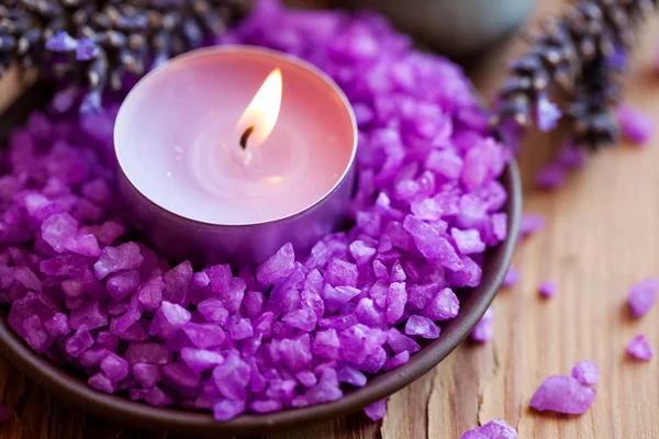 Candle in a saucer with salt baths and sprigs of lavender