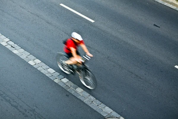 Man cycling on city street, motion blur