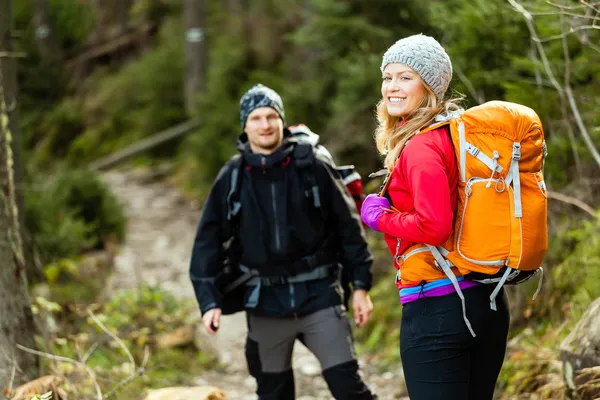 Couple happy hikers walking in mountains