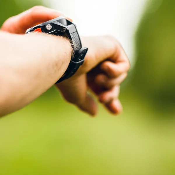 Cross country runner looking at sport watch