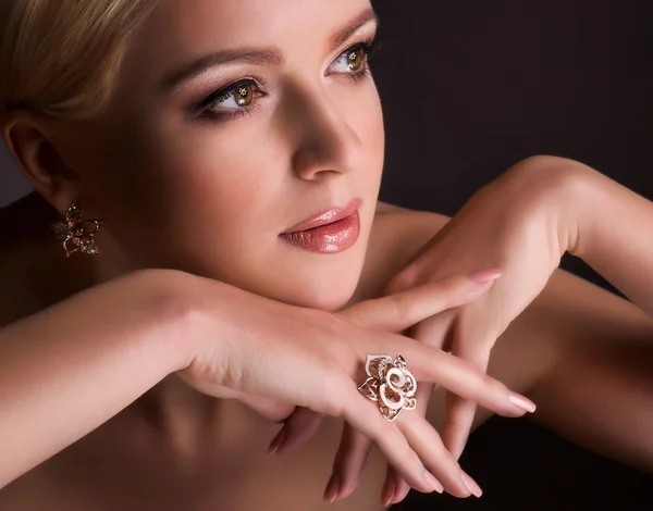 Portrait of beautiful young woman with makeup in luxury jewelry