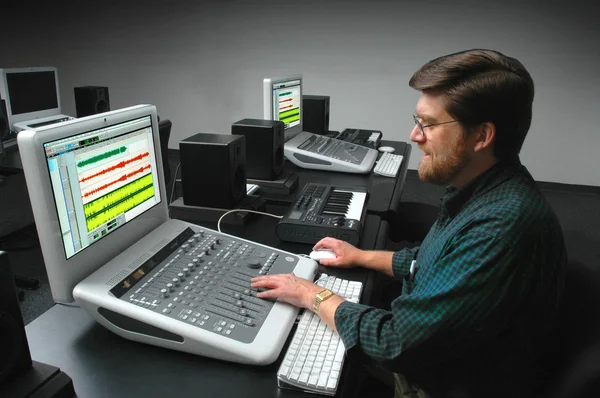 Man working at a digital sound mixing board