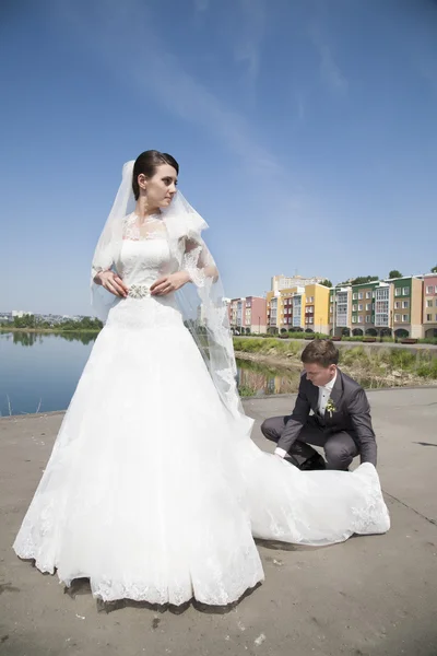 Groom straightens plume bridesmaid dresses