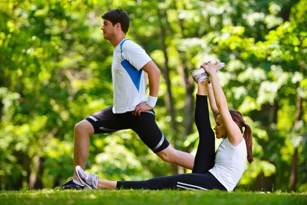 Couple doing stretching exercise after jogging