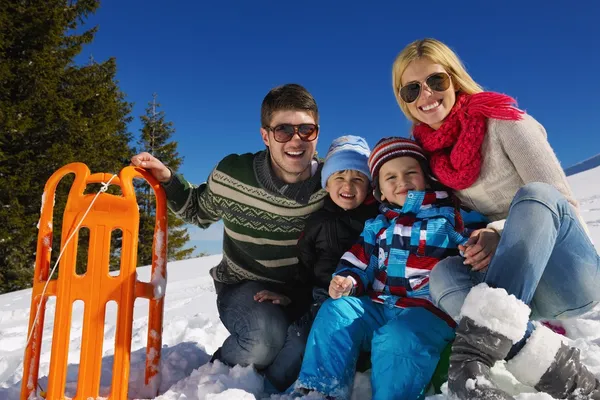 Family having fun on fresh snow at winter vacation