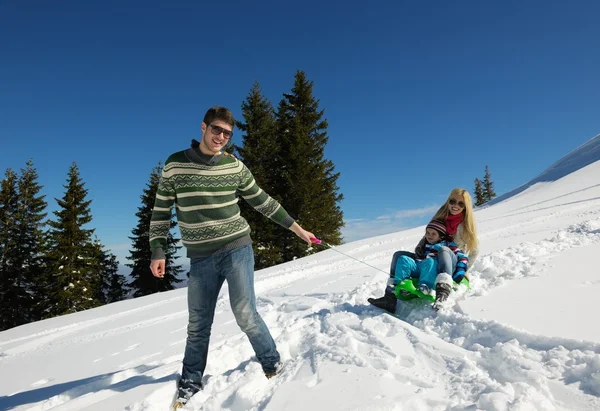 Family having fun on fresh snow at winter vacation