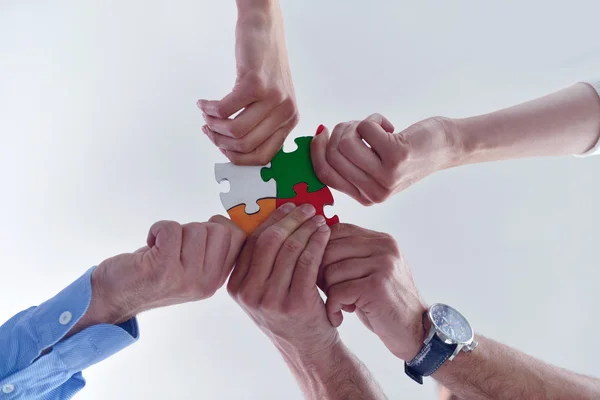 Group of business people assembling jigsaw puzzle