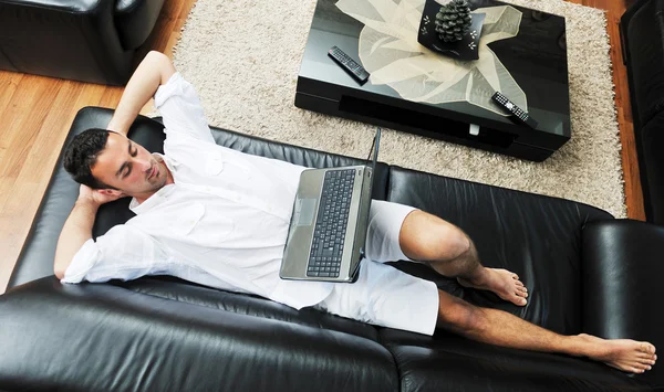 Portrait of a relaxed young guy using laptop at home