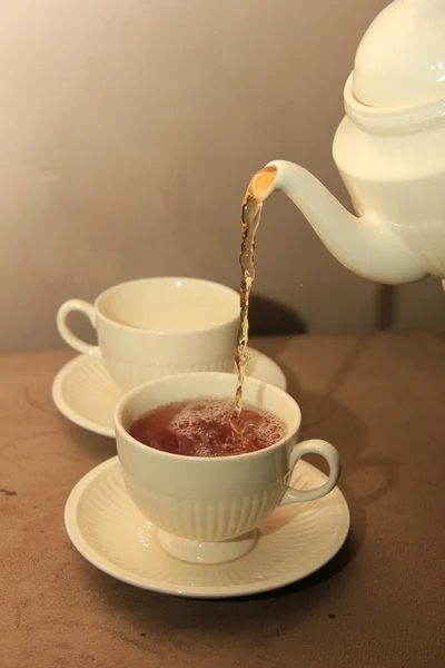Pouring tea in a classic white teacup