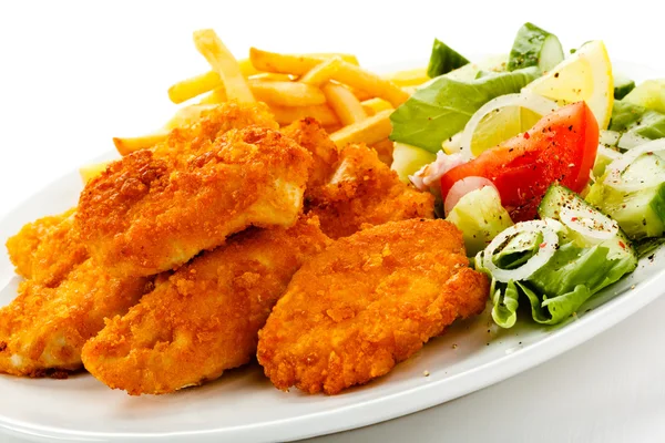 Fried chicken nuggets, French fries and vegetables