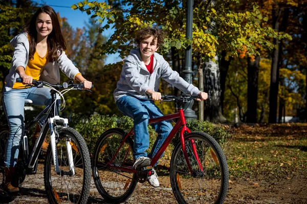 Urban biking - teens riding bikes in city park