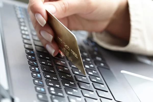 Woman holding credit card on laptop