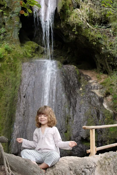 Little girl meditates in nature
