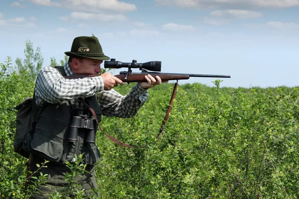 Hunter aiming with sniper rifle