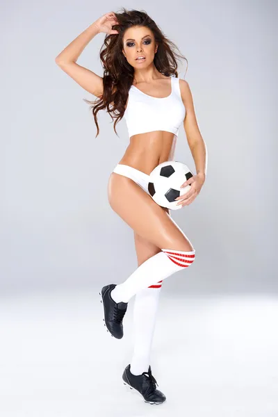 Sexy beautiful woman posing with a soccer ball