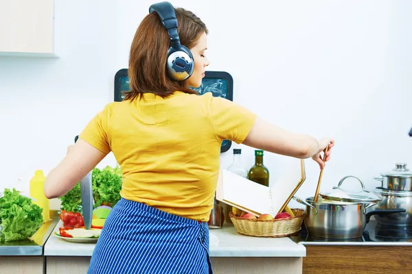 Woman cooking food with fun and listen music