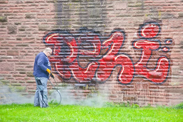 A worker washes a wall