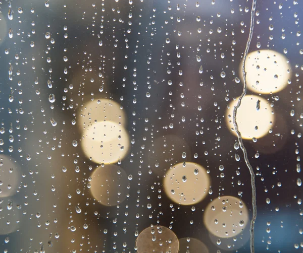 Rain on window with abstract lights