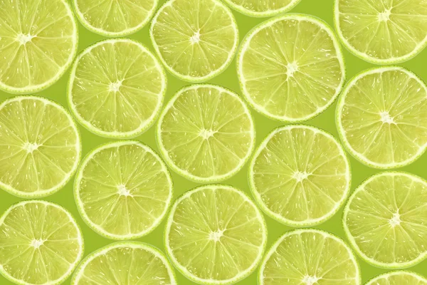 Abstract green background with citrus-fruit of lime slices. Close-up pattern